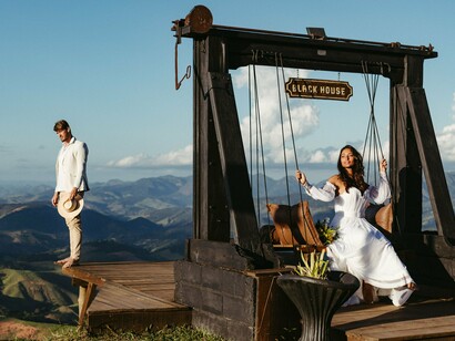 Um casal contempla a paisagem montanhosa a partir de um espaço de madeira, cercado pela natureza. A imagem evoca a ideia de intimidade romântica, que o artigo contrapõe à relação destrutiva entre Heathcliff e Catherine