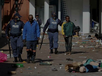 South African police officers apprehend a suspect who was involved in the protests against the government