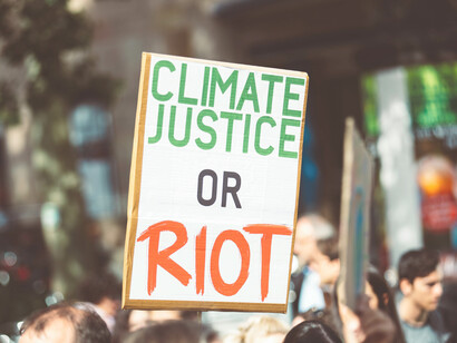 Climate change protesters march through city streets with campaign banners