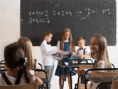 Schoolchildren are attentively participating in a lesson in front of the blackboard in the classroom