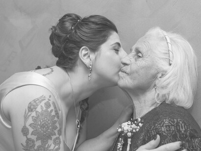 A woman lovingly kissing her grandmother