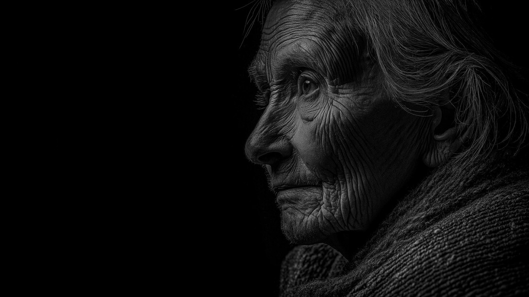 Em preto e branco, o perfil de uma mulher idosa revela um rosto marcado pelas rugas e uma expressão pensativa. A luz e as sombras realçam os traços de uma vida atravessada pelo tempo, conferindo ao retrato uma intensidade silenciosa. O envelhecimento transforma o corpo, mas não apaga a história, a identidade ou a dignidade de quem envelhece. Talvez seja justamente nesse rosto que encontramos um lembrete de que a força não precisa permanecer visível para continuar fazendo parte de quem somos