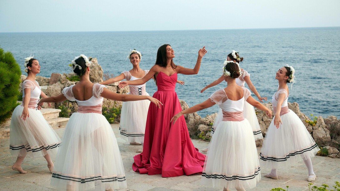 Tamara Radjenovic (center) singing while being surrounded by ballet dancers