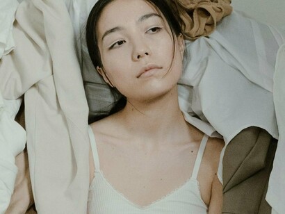 Mulher cercada de peças de roupa. A moda está em constante transformação. O que antes era um modelo confortável para algumas marcas, entrava em conflito com os valores de outras. Se o foco já foi a produção em massa, os guarda-roupas lotados e as escolhas impensadas, hoje a sustentabilidade ganha espaço, redefinindo essa dinâmica