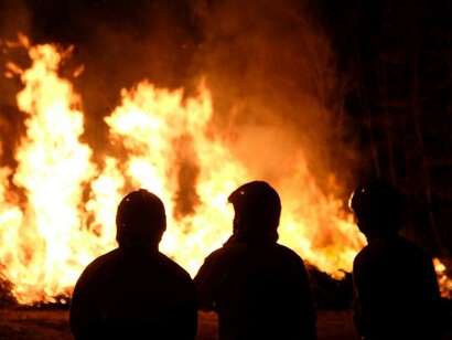 Firefighters observe a wildfire in the distance in Torino, Piemonte, Italy, as they prepare for action against the spreading flames