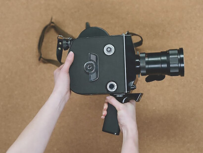 A hand holds an analog camera