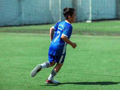 A determined young player racing into open space, symbolising the belief that every training session brings progress