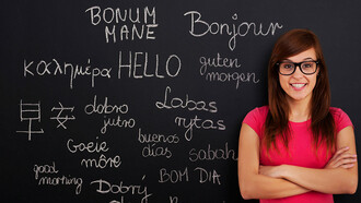 Learning different languages, young woman in front of a blackboard in a classroom