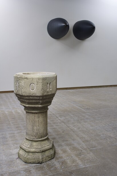 Fiona Banner, Installation shot with
Font 2015, Hand carved limestone baptismal font, 112 x 54 cm & Nose Art 2015, Graphite, Harrier Jump Jet nose cones, 107 x 79 cm (each), Courtesy the artist and Frith Street Gallery, London 
