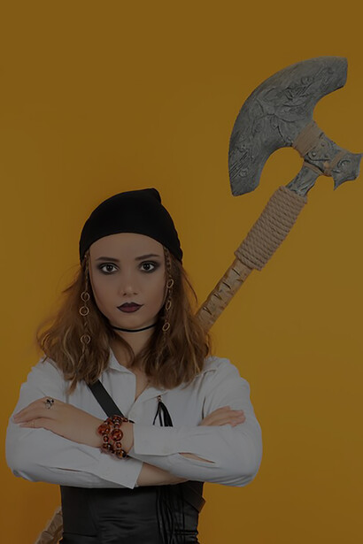 A confident young pirate girl crossed her arms and looking at the camera