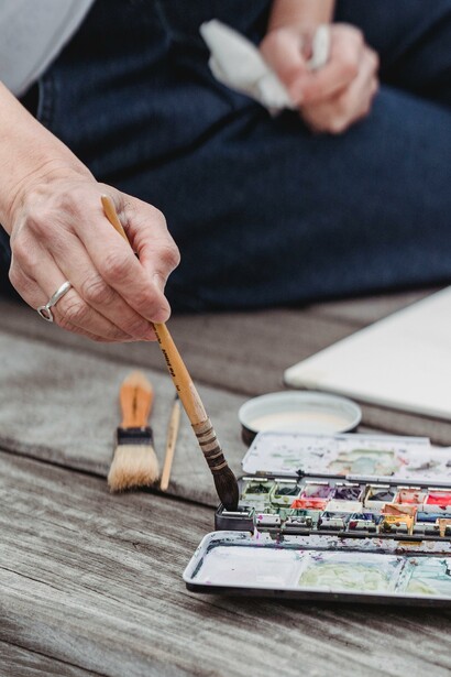 Person painting with watercolour paints