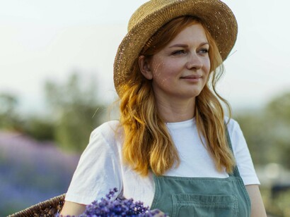 Surrounded by nature, a woman carefully gathers lavender, free from the pressures of time and obligation, finding fulfillment in the simple pleasure of being present