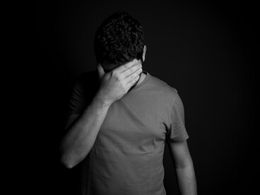 Com uma das mãos sobre o rosto, um homem esconde os olhos em um gesto de recolhimento e introspecção. A cena remete à dificuldade de afastar da lembrança aquilo que nos fez sofrer, mesmo quando outras experiências positivas poderiam ocupar esse espaço