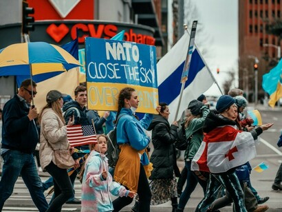 A group of people participating in an anti-war protest in Seattle USA, holding umbrellas to show support for Ukraine