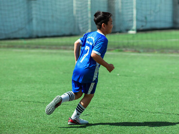 A determined young player racing into open space, symbolising the belief that every training session brings progress