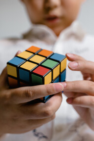 Criança participa de desafio com cubo mágico em uma gincana da escola