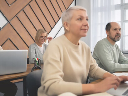 Older man and woman diligently working with computers
