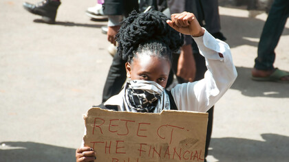 Young girl holding a 'Reject Financial Bill' sign during Kenyan protest