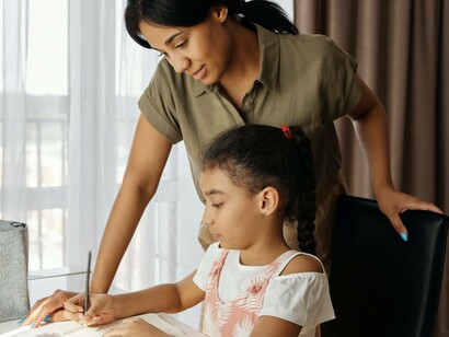A mother and daughter team in Africa writing down notes they discovered on the internet