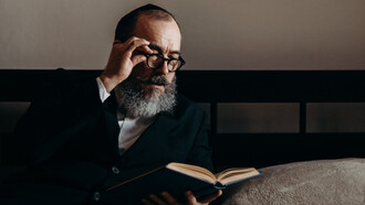Homem judeu lê atentamente um livro 
