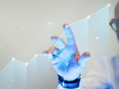 A businessman’s hand overlays a digital bar graph, illustrating a steady increase in growth and highlighting the impact of informed decision-making on business succes