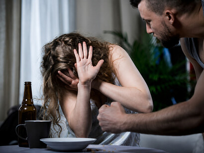 Fearful woman attempting to protect herself from an abusive partner