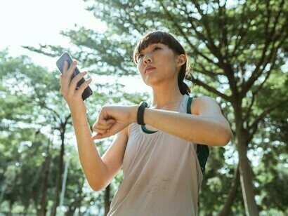 Une passionnée de fitness consultant les données de santé de son appareil portable, illustrant l’essor des technologies connectées qui suivent les activités quotidiennes et le bien-être.