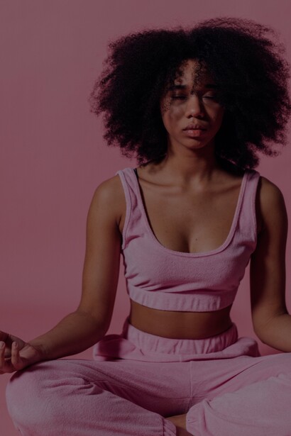 Mulher com top rosa meditando
