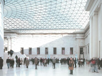 On the ground level of the British Museum where people are marvelling the architecture