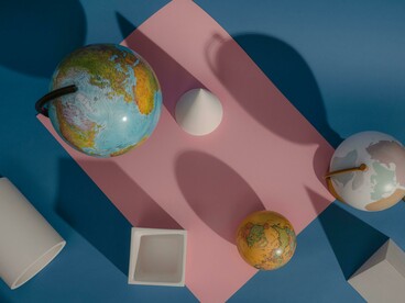Vista aérea de globos terráqueos y elementos de diseño, evocando la complejidad de un sistema multipolar