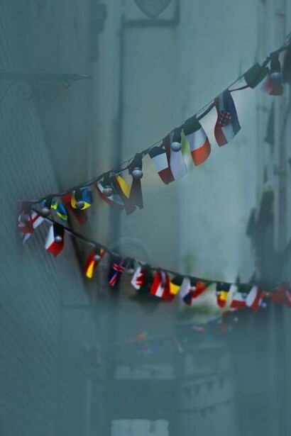 Flags of diverse nations; global citizenship is not merely about collecting passport stamps or mastering multiple languages