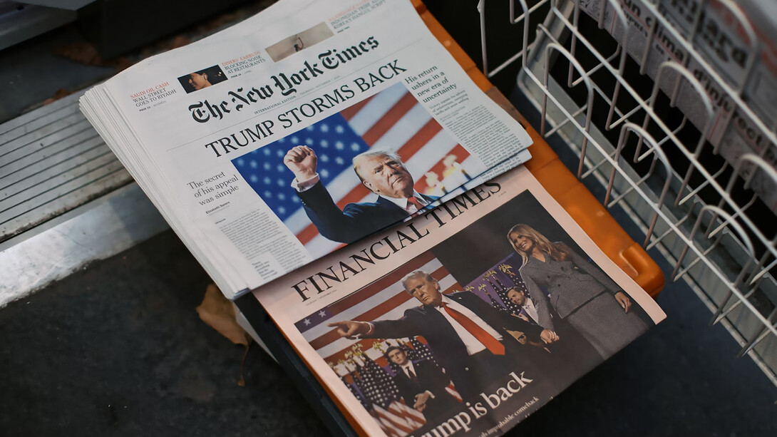 The New York Times and Financial Times newspapers displayed on a stand in Paris, France, offering a glimpse into global news and finance saying "Trump storms back" 
