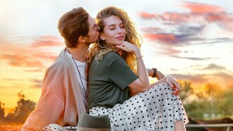 Casal heterosexual demostrando afeto ao pôr do sol
