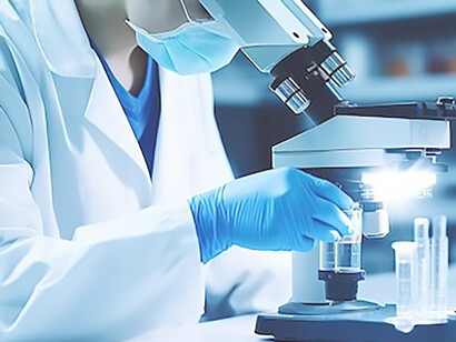 A geneticist in a lab coat, wearing protective gear, carefully examines test tubes and conducts microscopic analyses