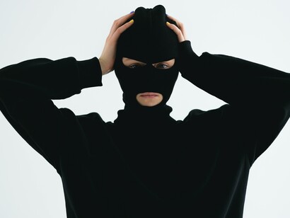 Criminoso utilizando balaclava levanta as mãos