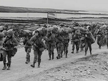 Soldados argentinos capturados en Goose Green mientras son custodiados por un Royal Marine británico el 2 de junio de 1982, durante la Guerra de las Malvinas