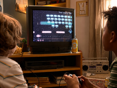 Two teenagers playing classic video games on an old television, sharing a nostalgic gaming experience filled with fun and friendly competition