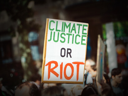 Letrero en una manifestación que dice: 'Justicia climática o disturbio'. La agenda climática oculta una guerra por el control de recursos vitales