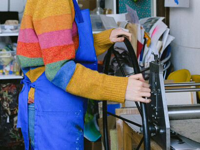 An old-fashioned printing press, operated via iron wheel