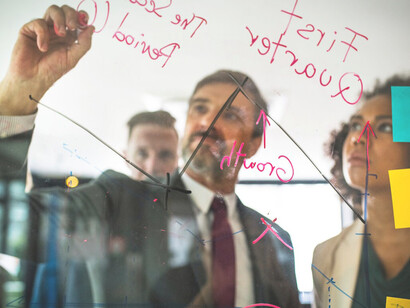 Business professionals strategizing on a glass wall, focusing on goal setting, career planning, professional growth, and developing an actionable plan