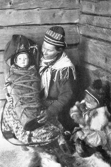 A Sámi mother with her children, embodying the deep cultural traditions of the Sámi people, as they continue their way of life amidst the challenges of a rapidly changing world