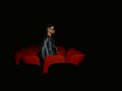 Um homem com uma jaqueta de couro preta dentro do cinema