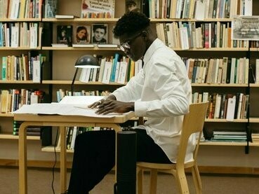 Homem em biblioteca. O conhecimento acadêmico pode ser adaptado às realidades distintas, por meio do empírico, tornando as teorias mais aplicáveis e relevantes para situações específicas. Por exemplo, uma teoria educacional pode ser ajustada considerando práticas empíricas em comunidades de difícil acesso