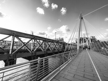 Pedestrians on the Golden Jubilee Bridge overlooking the River Thames, London, UK