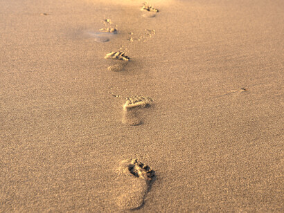 Mujer deja el rastro de sus huellas por la arena en Escocia, Wielka Brytania