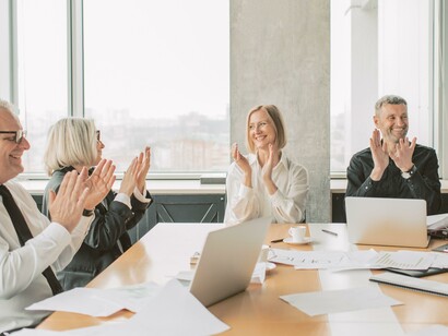 Colegas adultos batendo palmas em reunião de trabalho