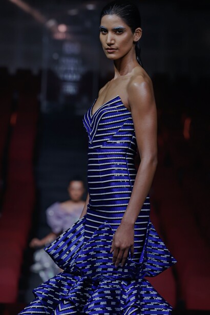 Modelo desfila com vestido azul tomara que caia com listras