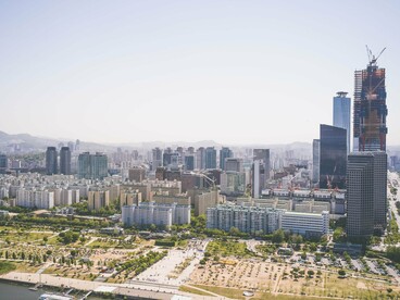A skyline of Seoul, South Korea, with a skyscraper under construction, representing the nation's commitment to building long-term economic strength 