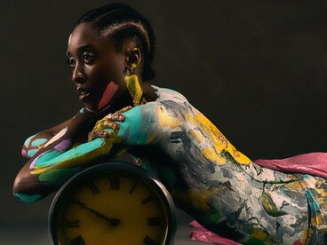 A painted human form posing with a clock, symbolising the personal journey behind every creative act