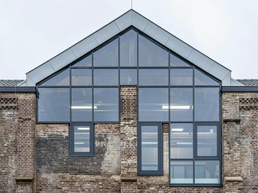 An old warehouse updated with striking glass additions, highlighting the redefinition of functional spaces